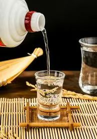专业调酒师正在品尝酒样,手持透明酒杯,专注神情,现代化实验室环境